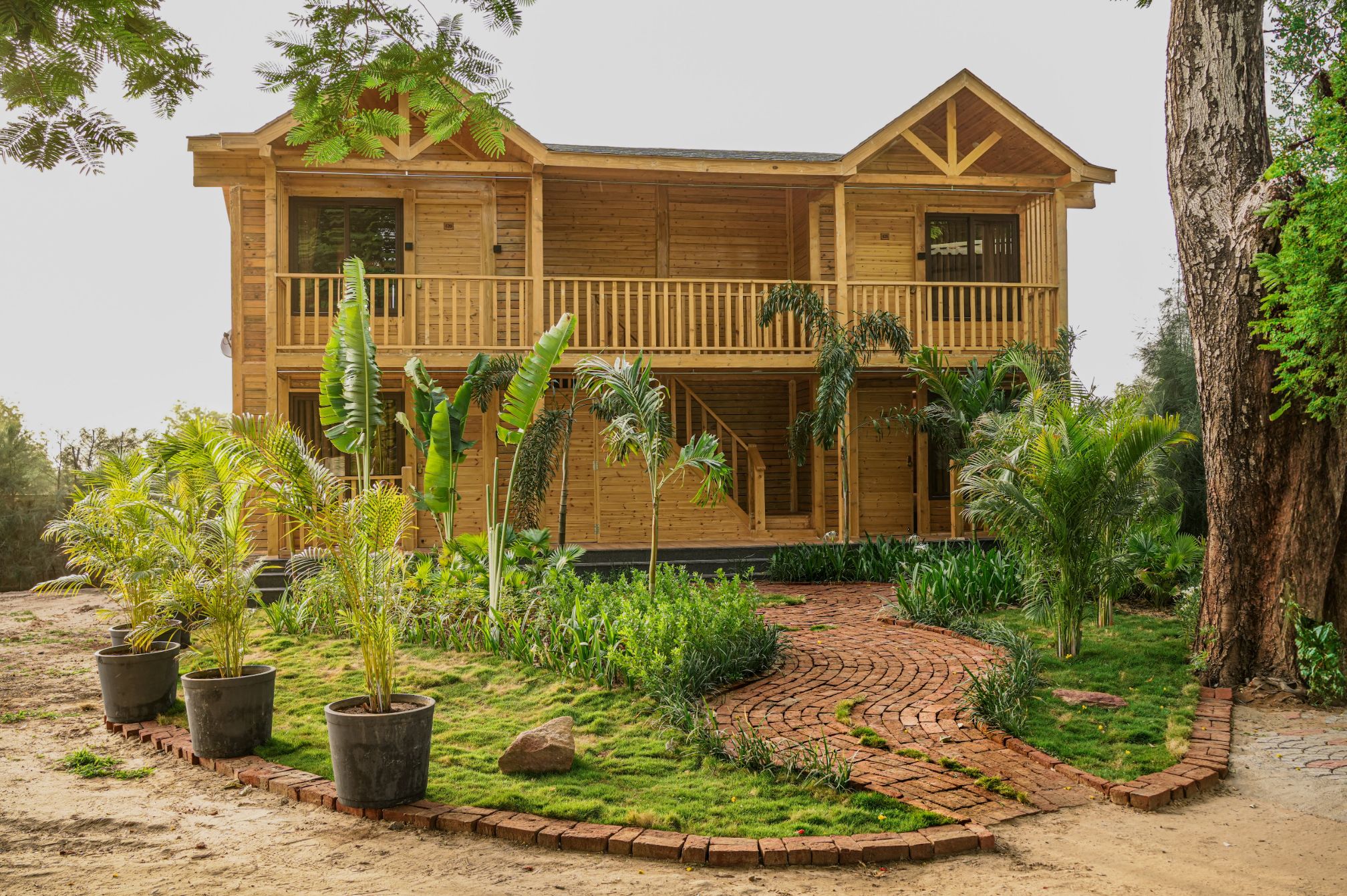 Beautiful exterior view of wooden cottage with lush garden at Roadies Rostel ARC Resort.