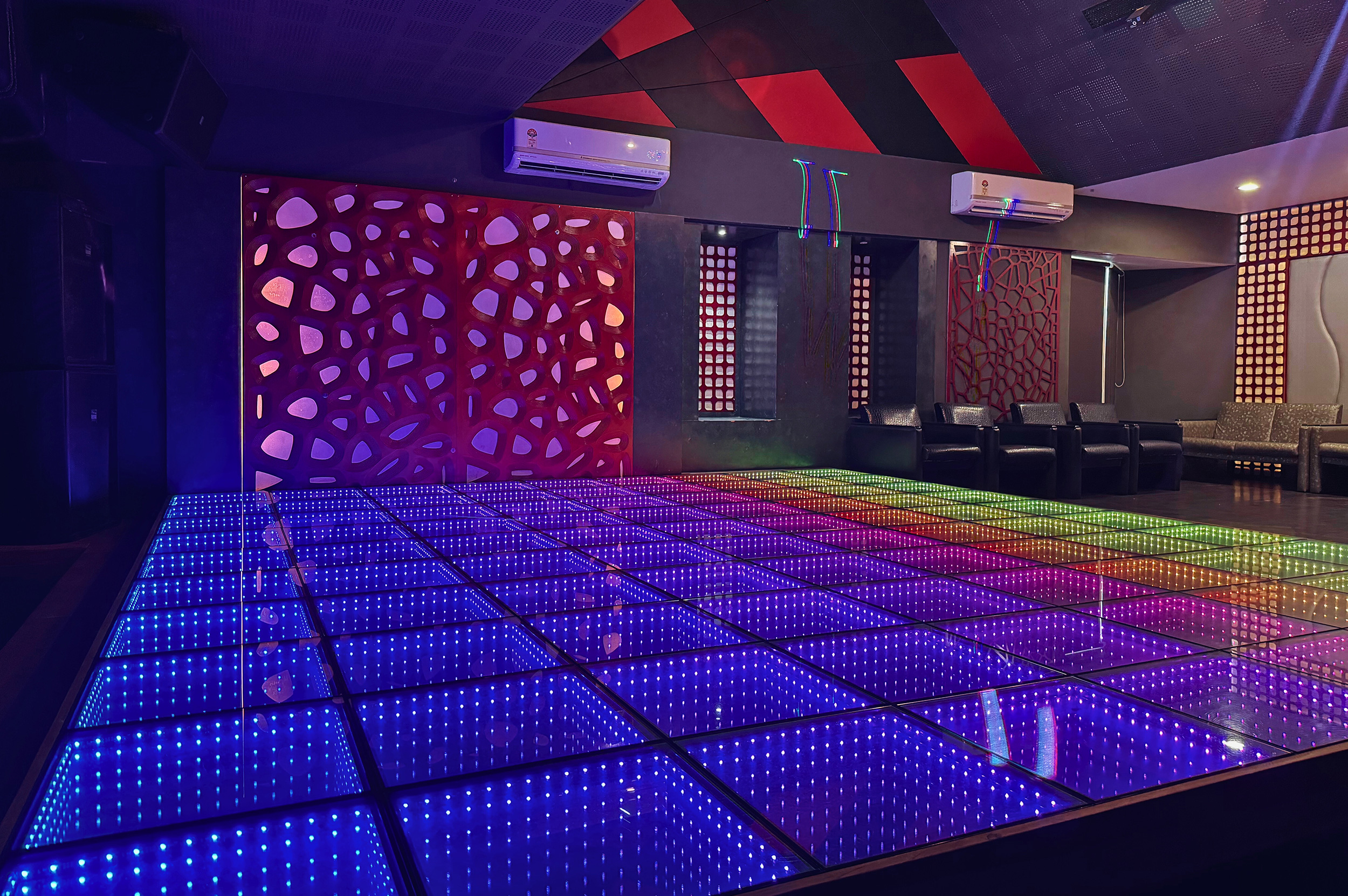 Spacious discotheque at Roadies Rostel ARC Resort with LED-lit dance floor and plush seating, perfect for private parties and celebrations near Ahmedabad