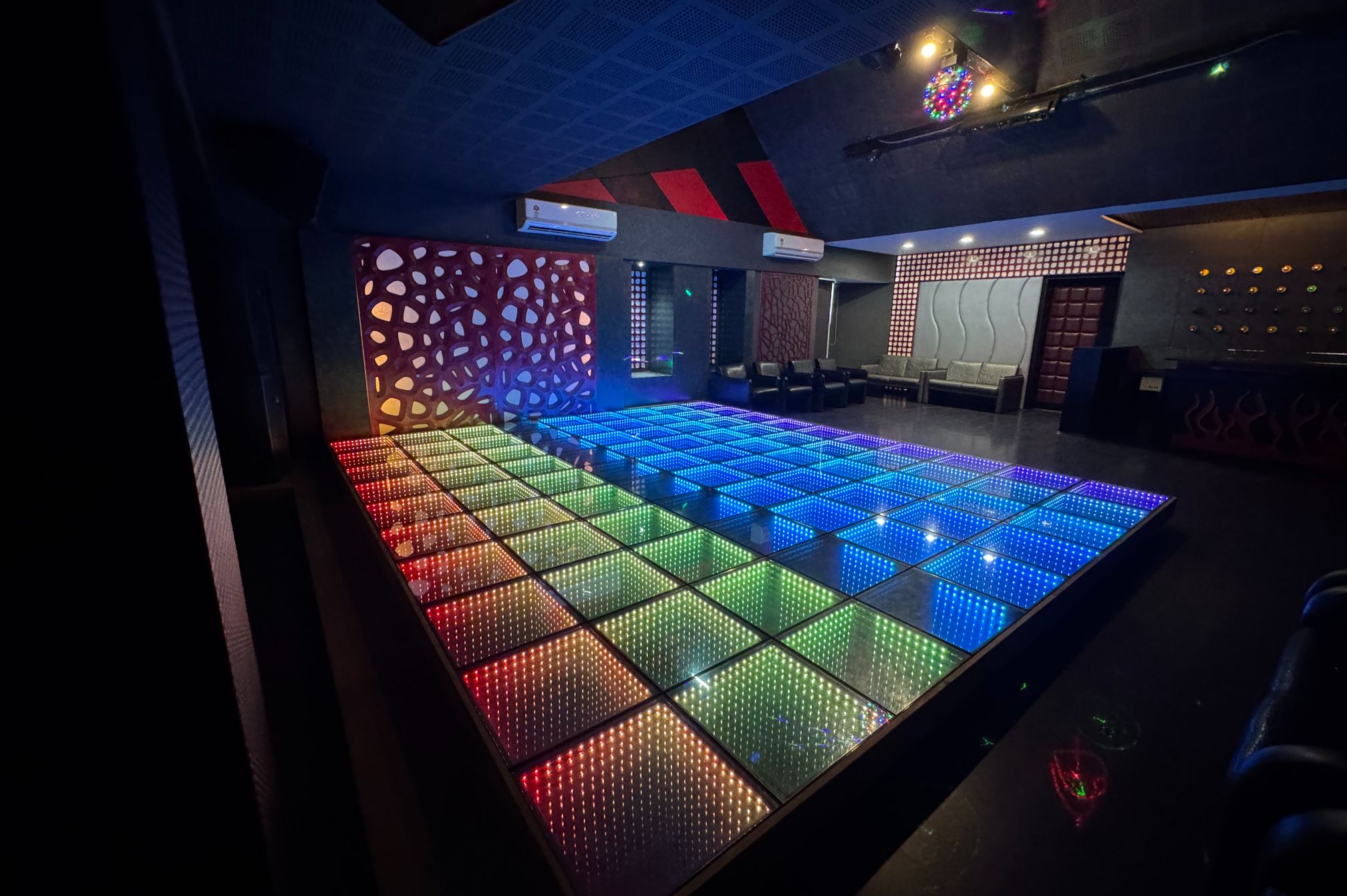 Color zone LED dance floor creating an exciting nightlife atmosphere at Roadies Rostel near Ahmedabad