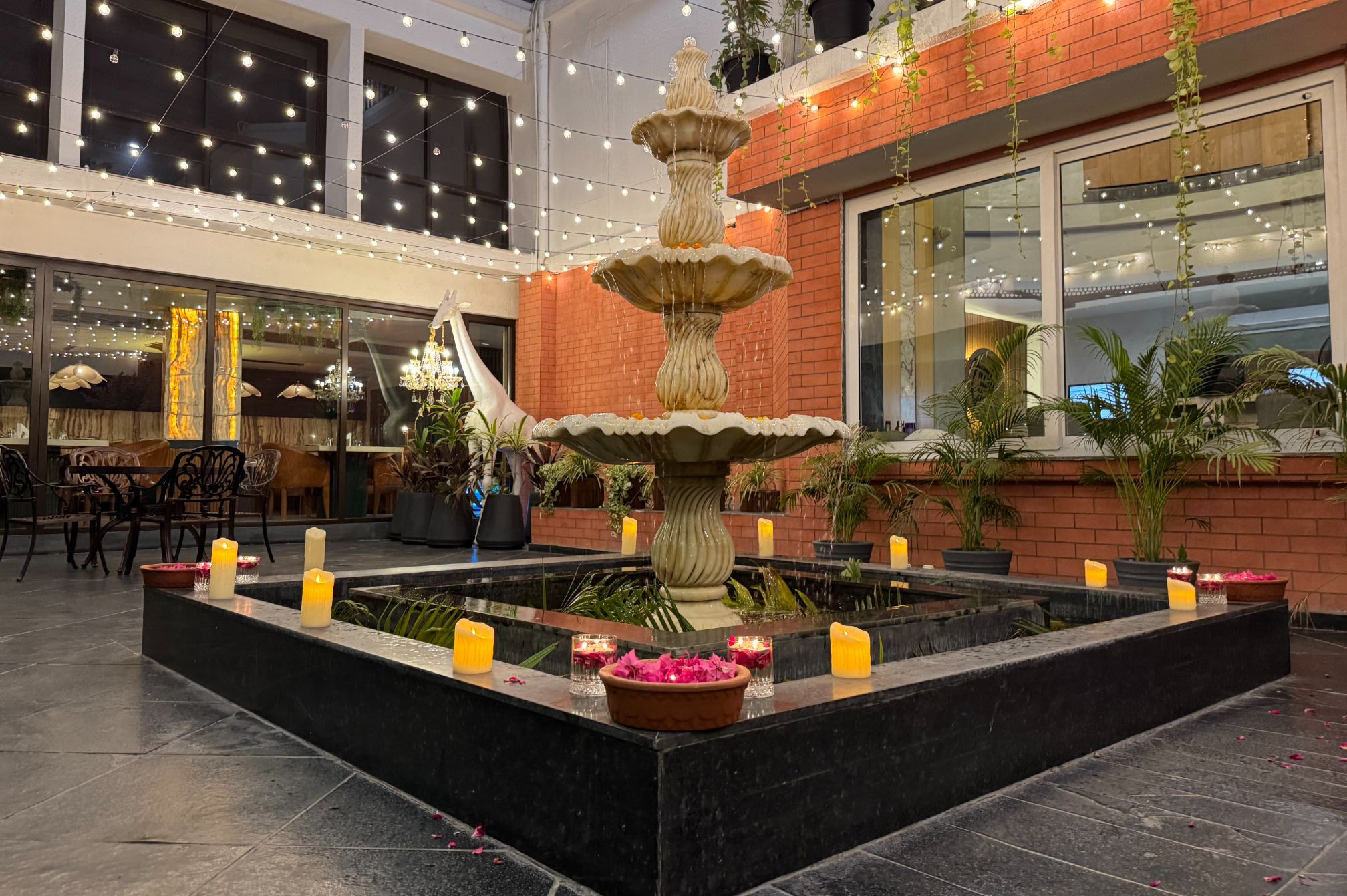 Decorated courtyard with fountain and evening lights at Roadies Rostel day picnic resort