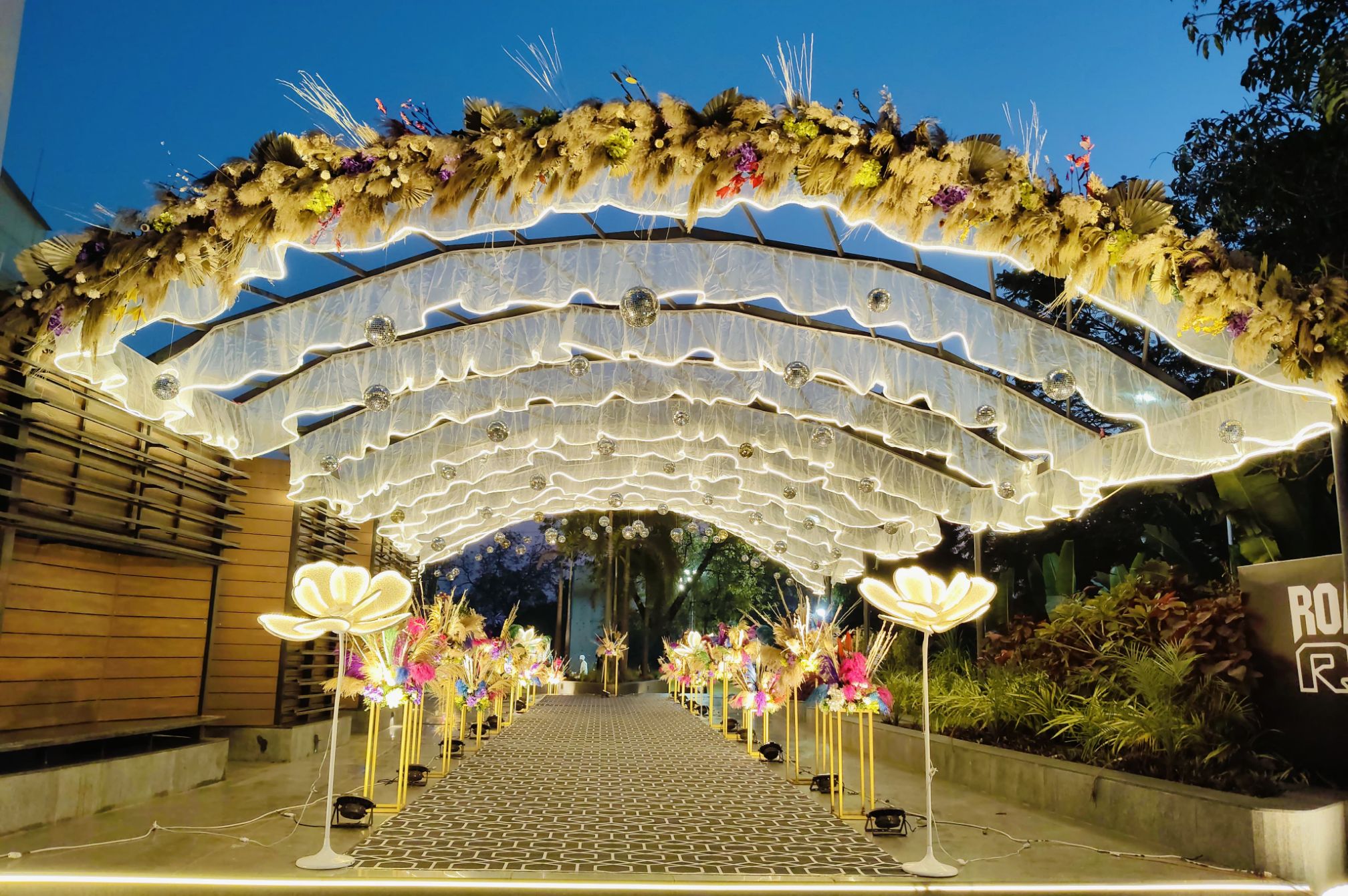 Stylishly designed wedding entrance gate with lighting and floral arrangements at a luxury resort near Ahmedabad.